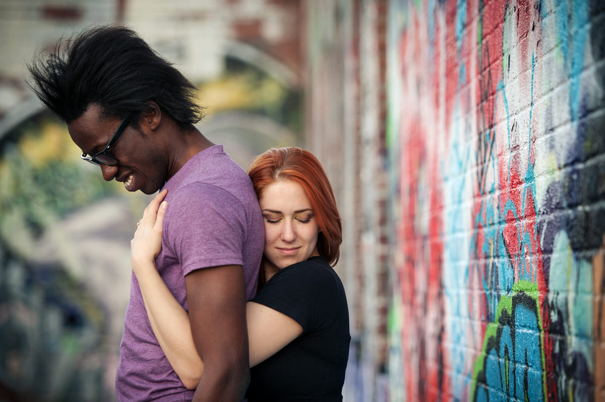Couple hugging in graffiti building