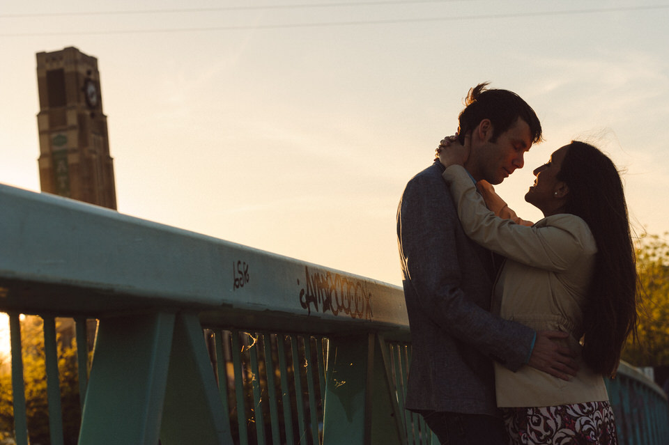 Couple on a bridge at sunset with the Atwater Tower behind them