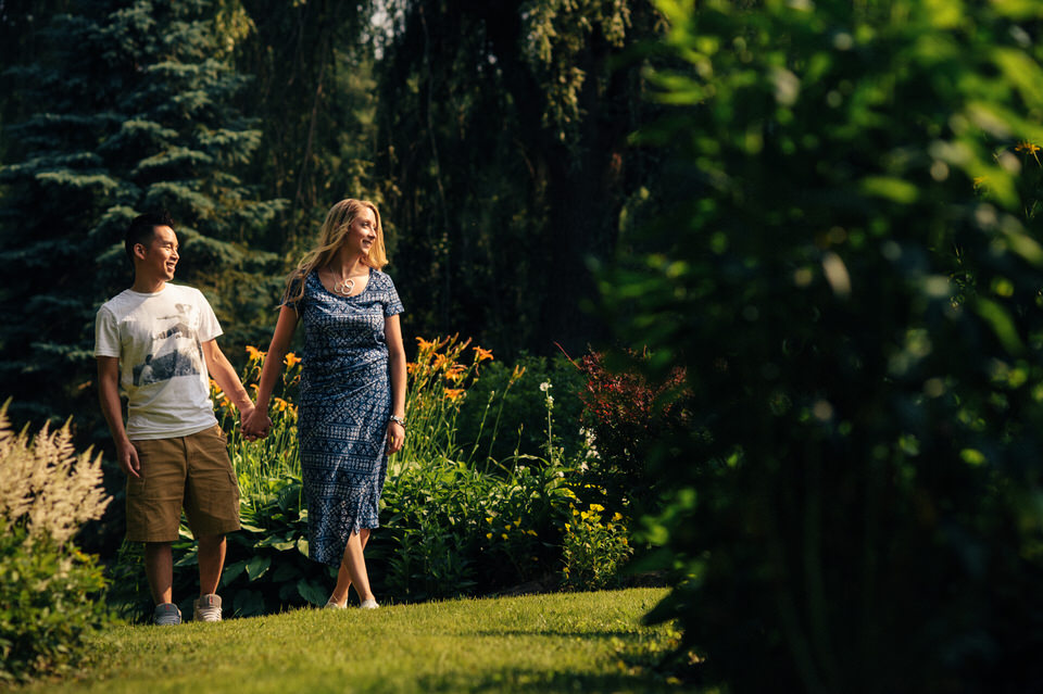 Engaged couple walking in a backyard garden
