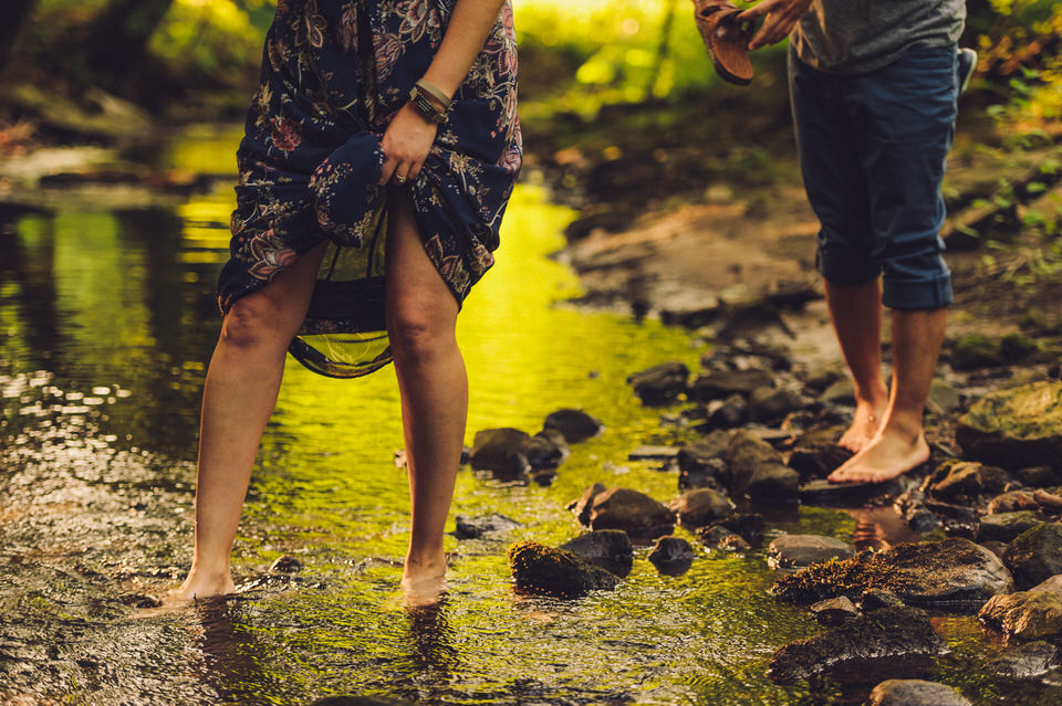 Feet of engaged couple crossing a creek
