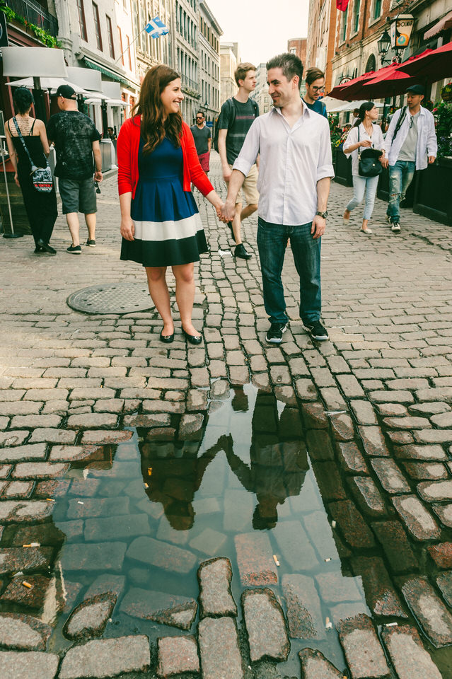 Couple holding hands with reflection in puddle