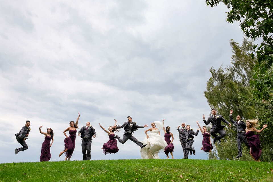 Wedding party jumping on a hill