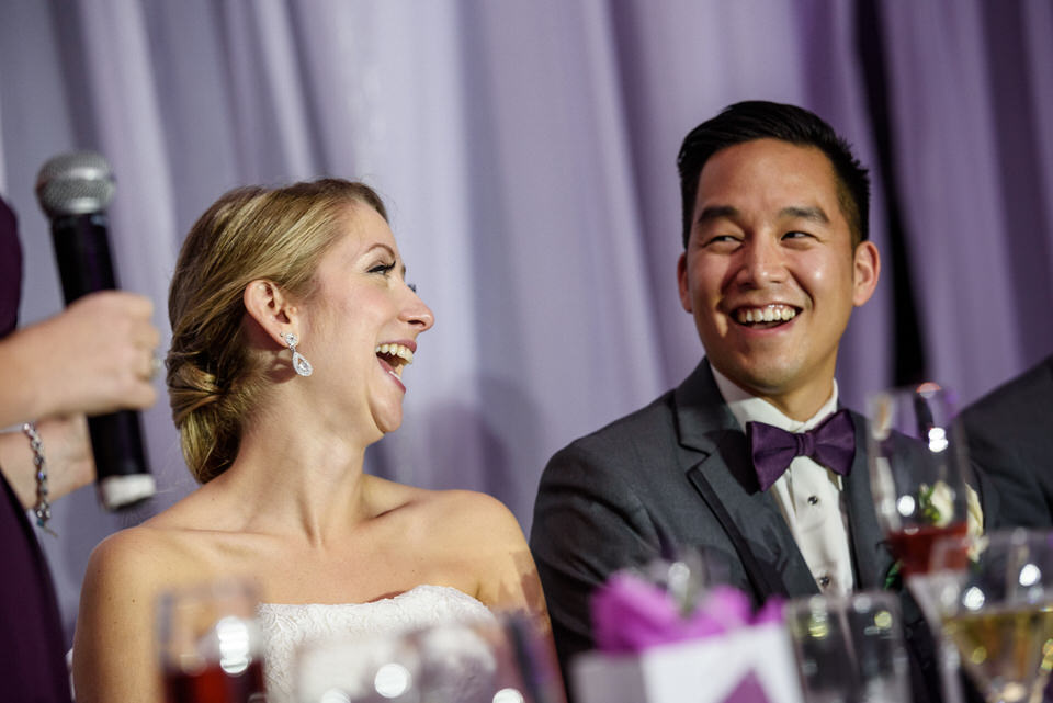 Bride and groom laughing during wedding speech