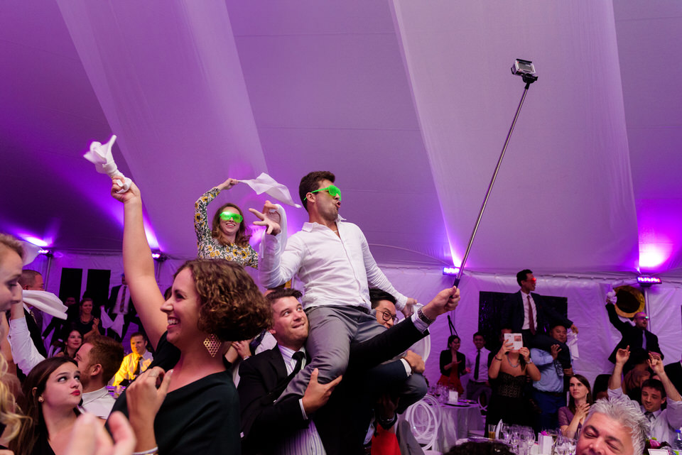 Guests dancing on chairs at wedding reception