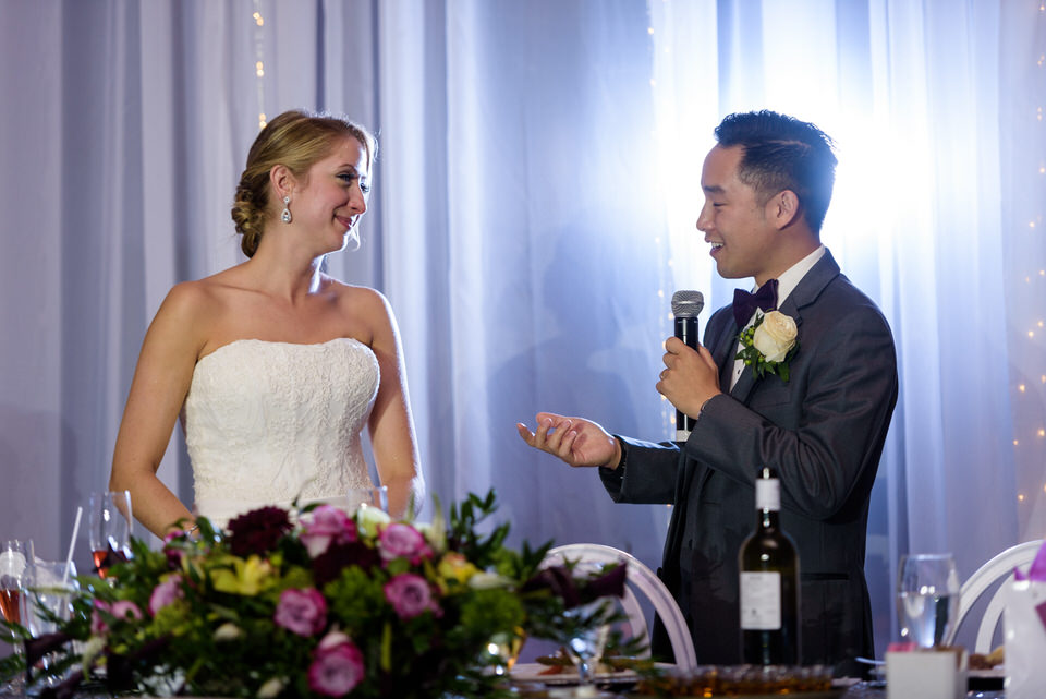 Groom giving speech and bride smiling at him