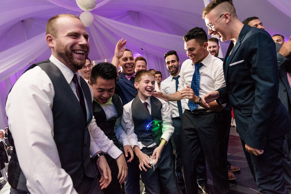 Everyone laughing as a young boy has caught the garter belt