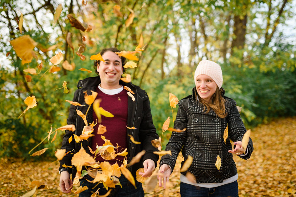 Smiling couple surrounded by autumn leaves