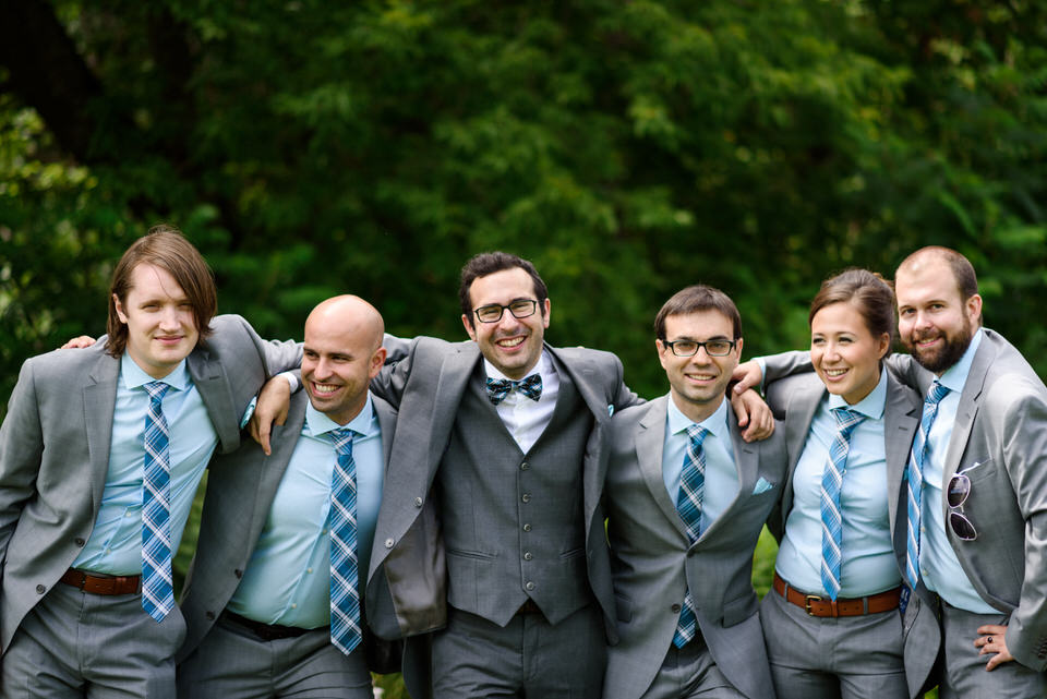 Groom with arms around friends