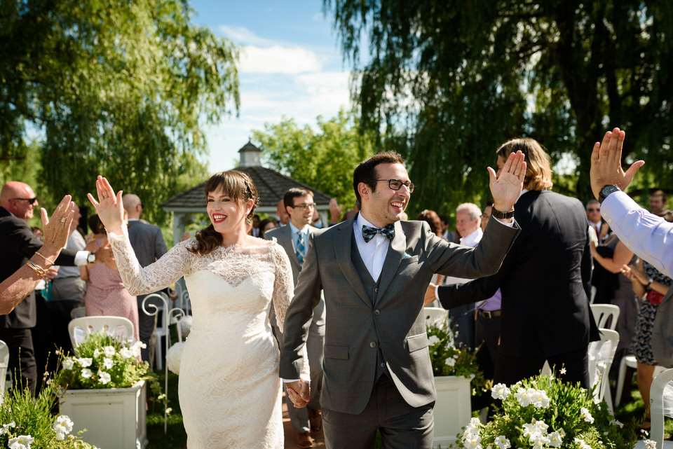 Wedding couple giving high fives to guests as they walk down the aisle