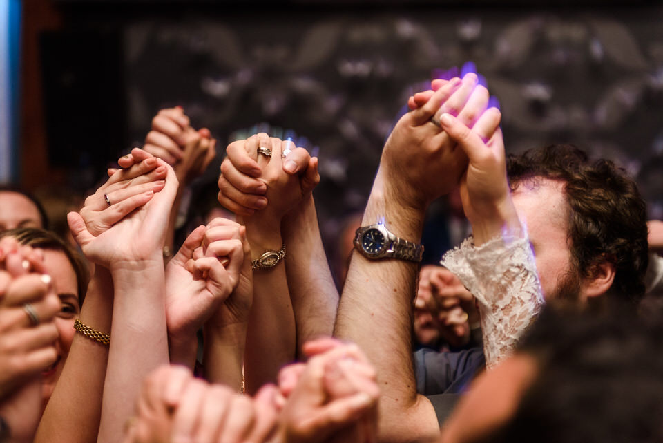 Close up of many hands clasped together during hora dance