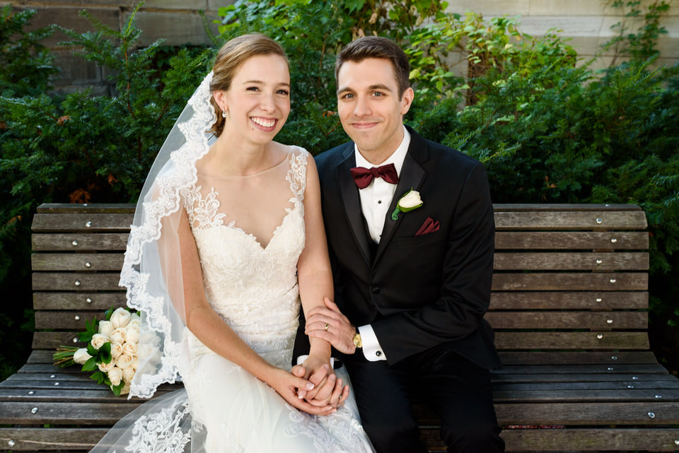 Wedding couple sitting on bench in front of church