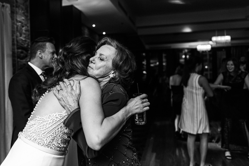 Bride hugging her mother at wedding reception