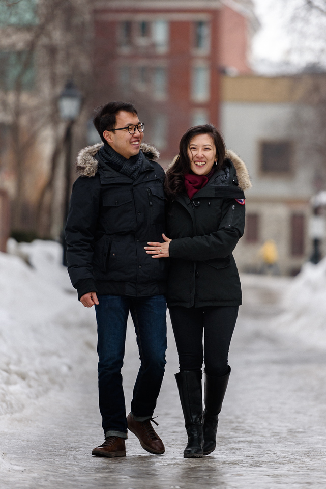 Winter engagement photo of couple walking on icy path in Old Montreal