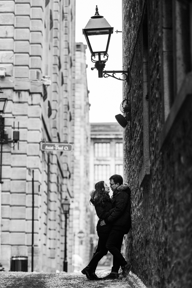 Black and white engagement photo in Old Montreal alleyway