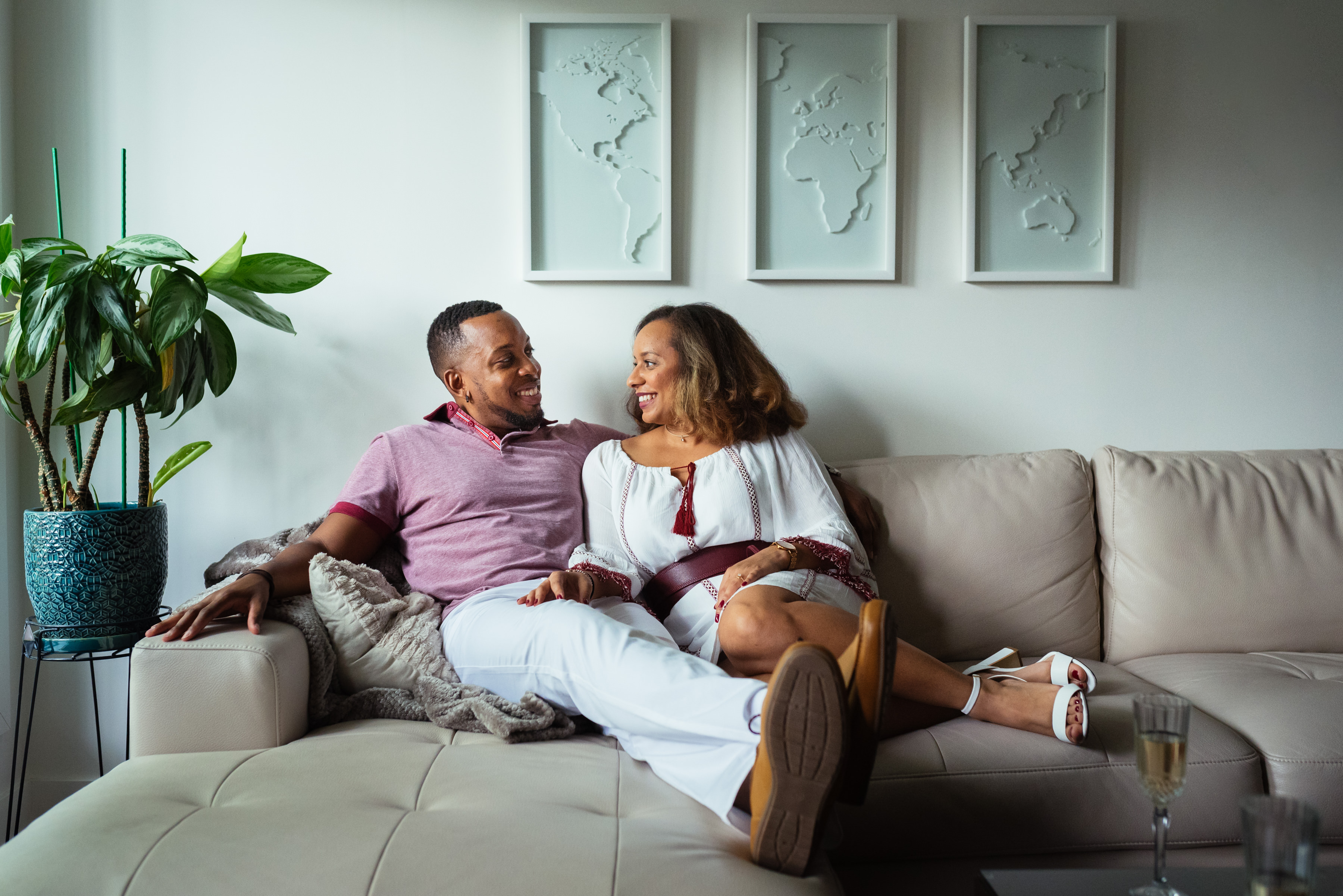 Couple sitting on their couch for at home engagement photos