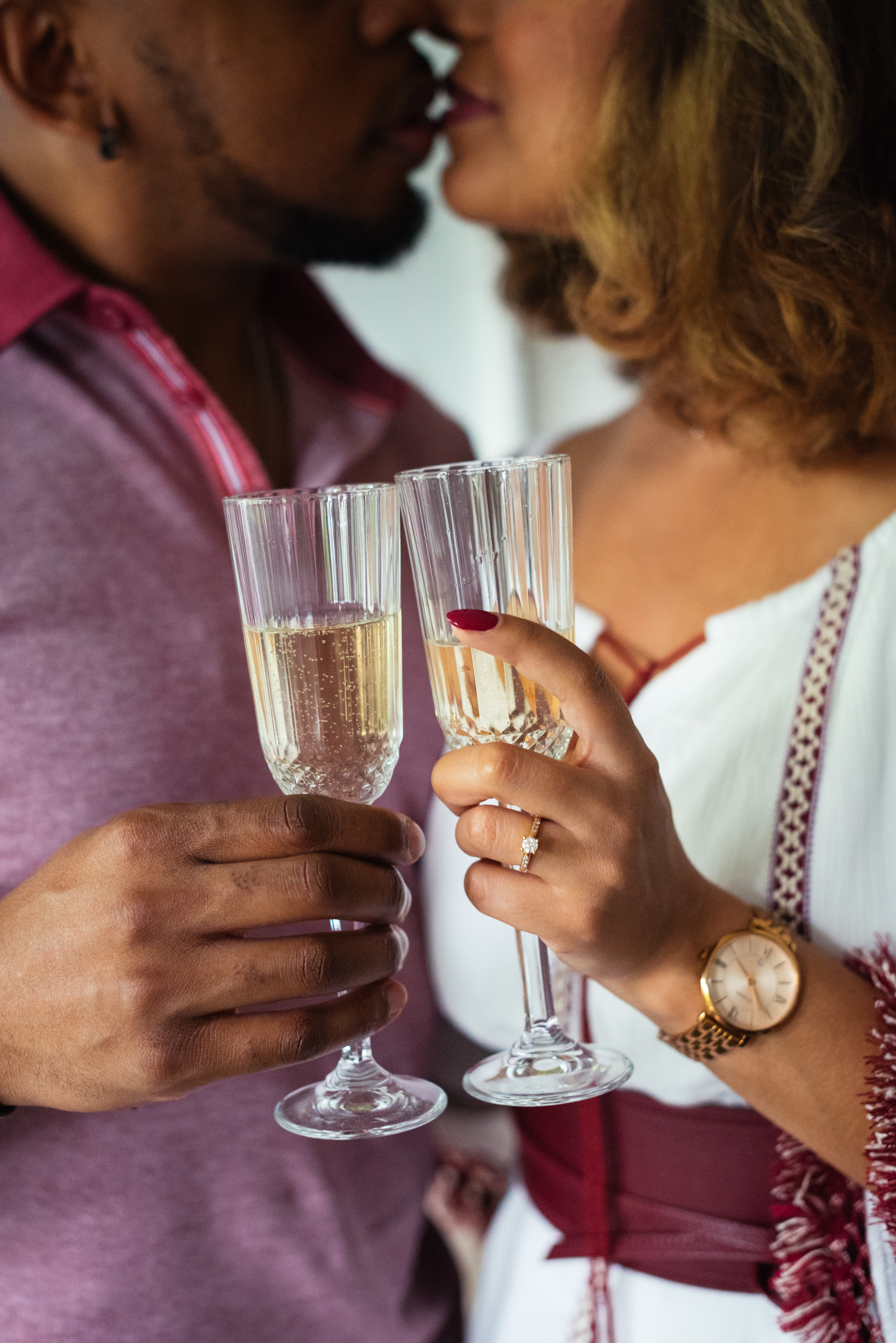 Closeup of champagne flutes with engaged couple