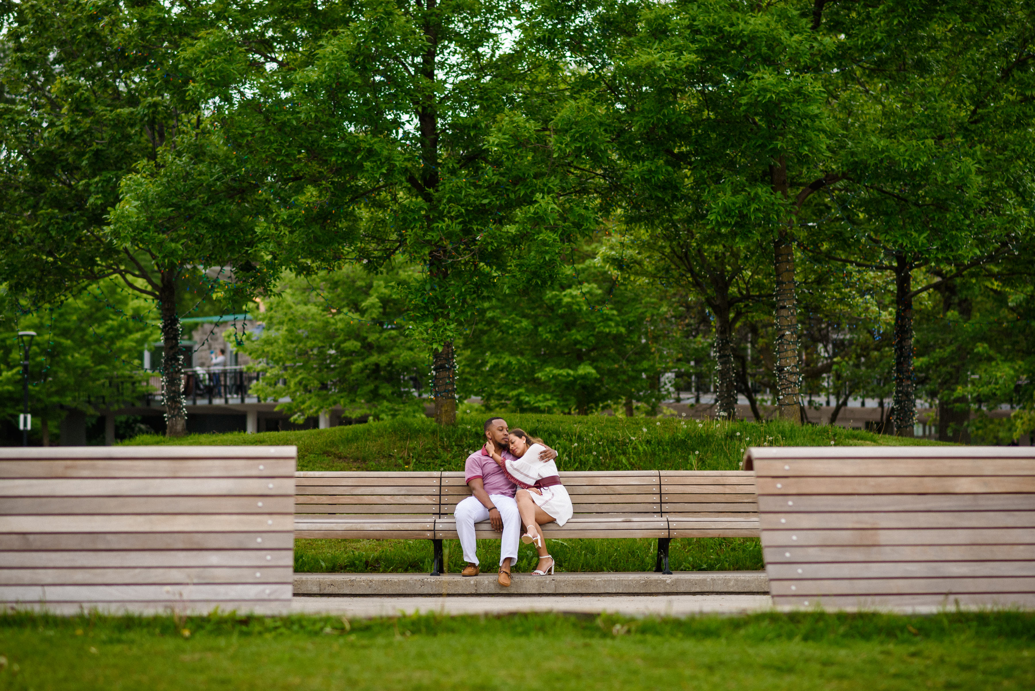 Engaged couple sitting on benches in Mount Royal Park