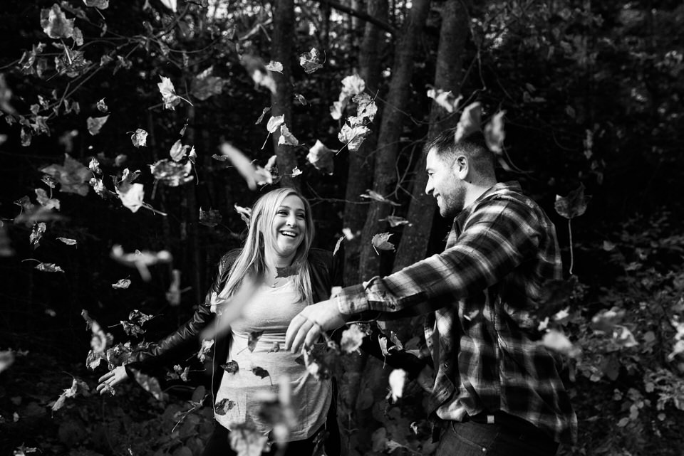 Couple throwing autumn leaves into the air